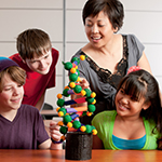 Middle-school aged kids look at a DNA diorama with their teacher