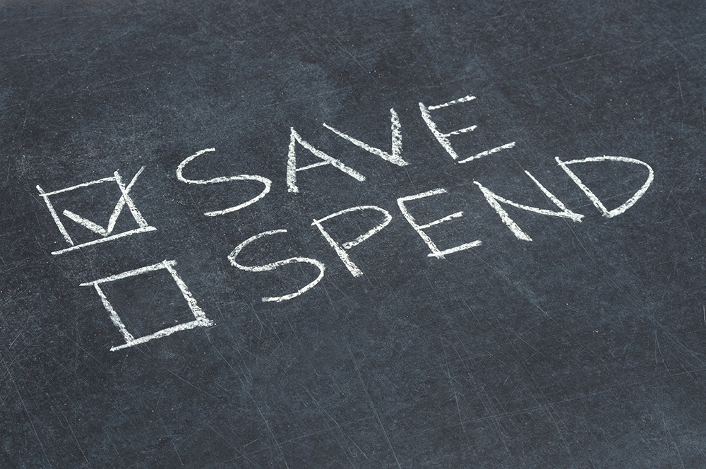 Chalkboard with the words "Save" and "Spend" each with a checkbox next to them. The box next to "save" has been checked.
