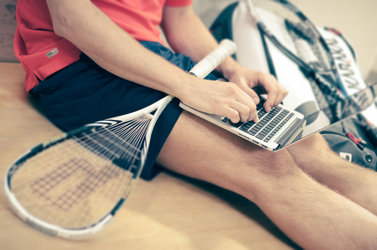 Consumer healthcare decision making illustrated by a man sitting on the ground with both a laptop and a tennis racket on his lap.