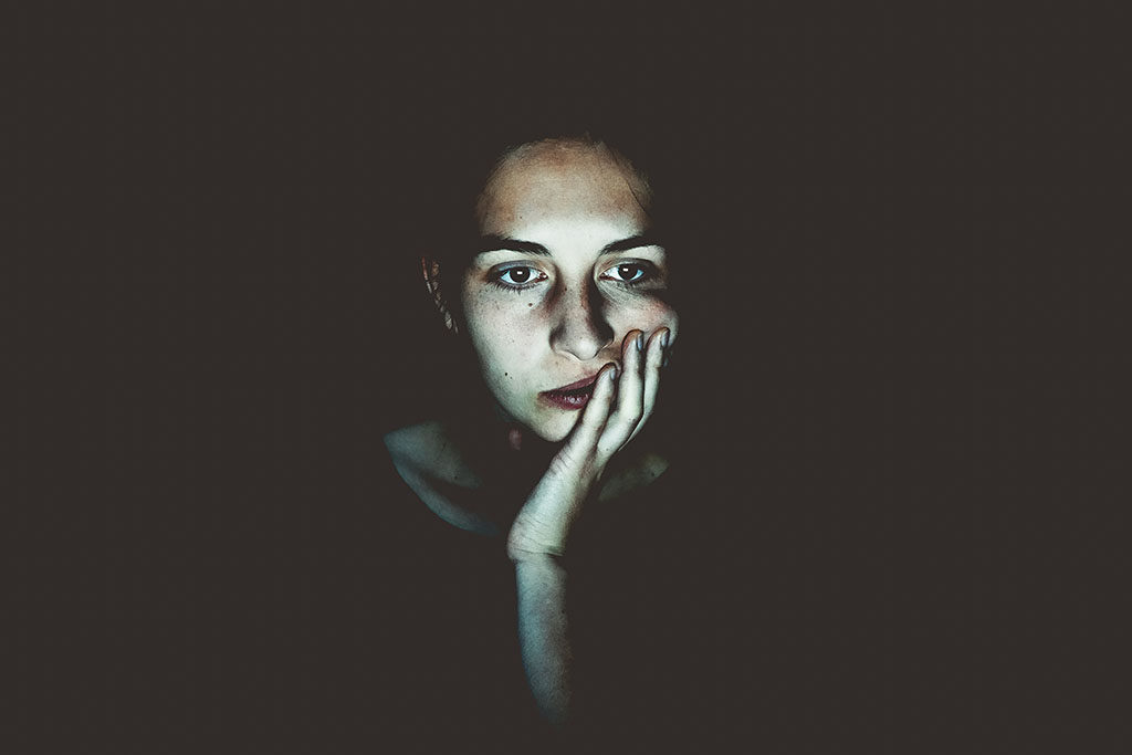 Financial anxiety: A woman's face lit up by a screen in a dark room