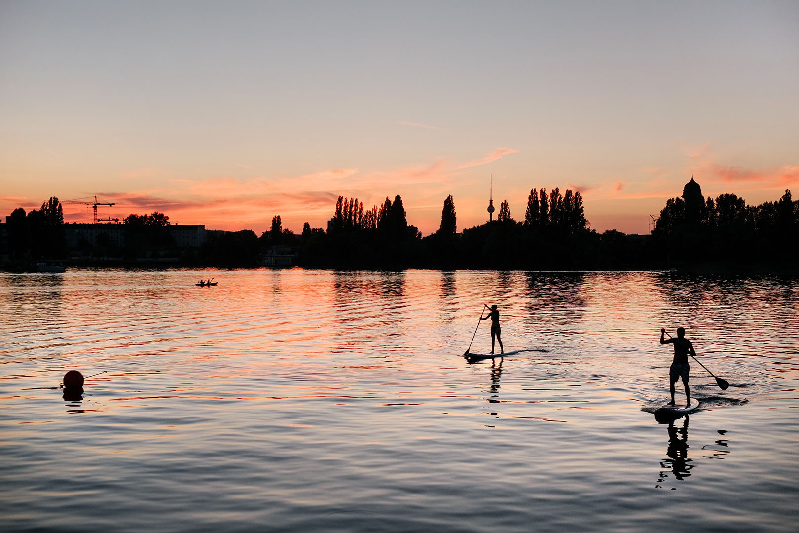 Health and Wealth: Illustrating a balance between the two with a photo of two people paddle boarding on a lake at sunset