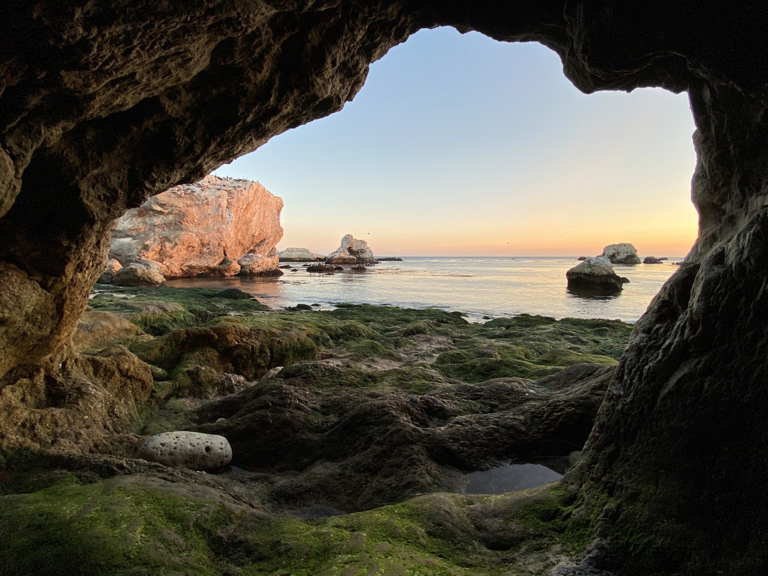 A photo of a cave opening that leads to the seashore