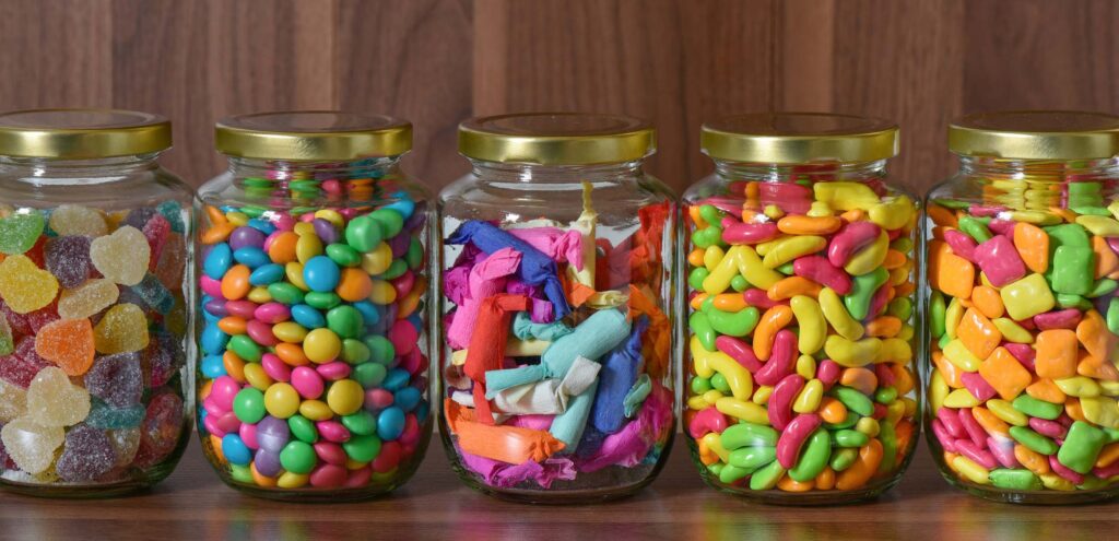 Different types of candy sorted into different glass jars