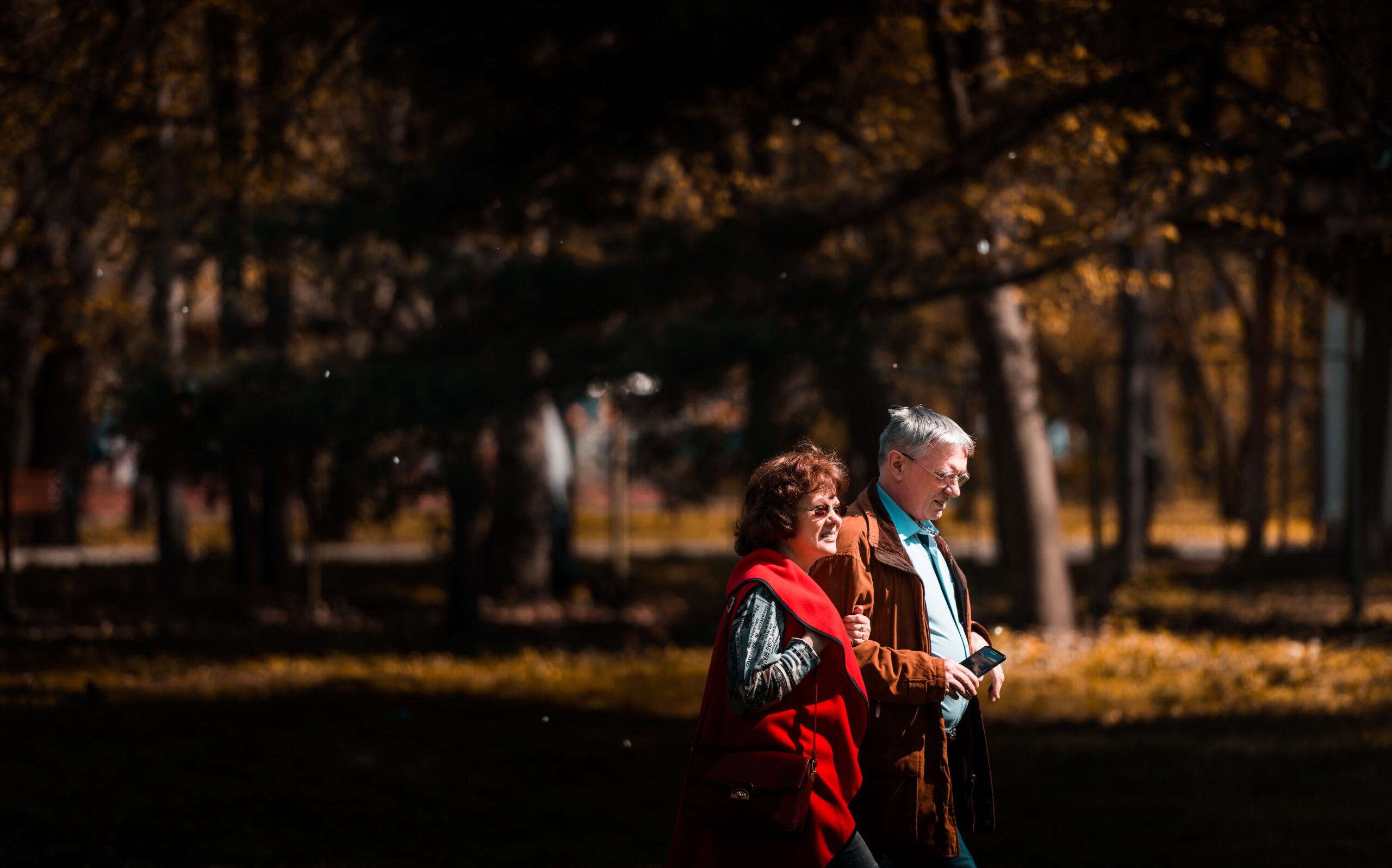A middle-aged couple walking through a park