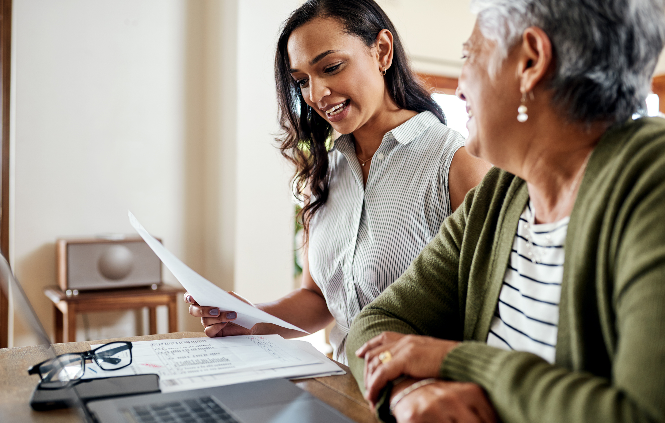 Transforming an industry conversation: a woman and her mother discussing papers in front of a laptop