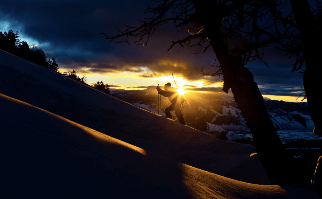 Climbing up a snow covered mountain at dawn or dusk