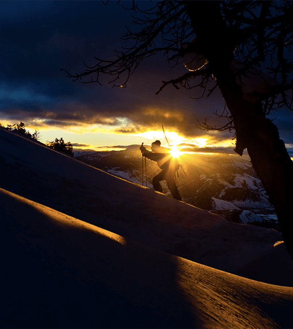 Climbing up a snow covered mountain at dawn or dusk