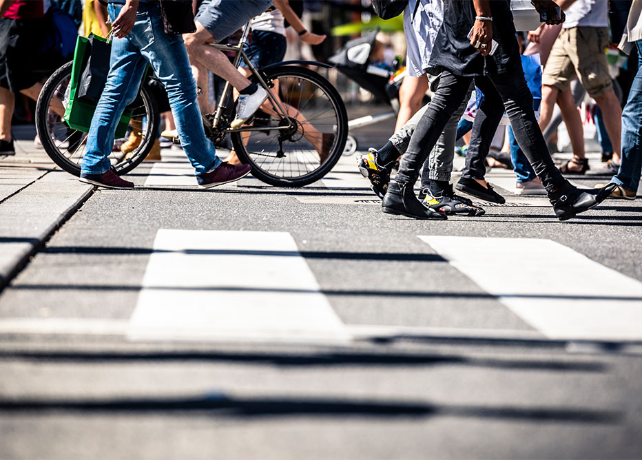 People moving forward on pedestrian crossing, on foot and by bicycle